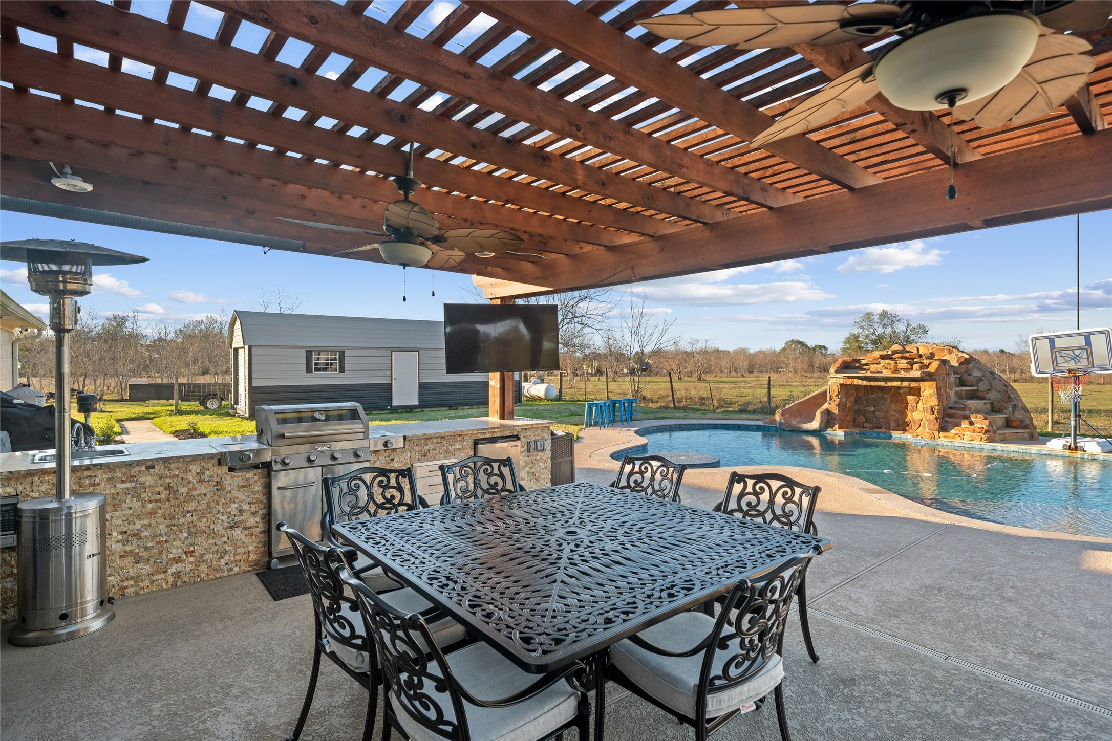 43910 Highway 290 Business Prairie View, TX 77484 - Photo 34 of 49 Covered outdoor kitchen with built-in grill, dining area, and pergola ceiling.