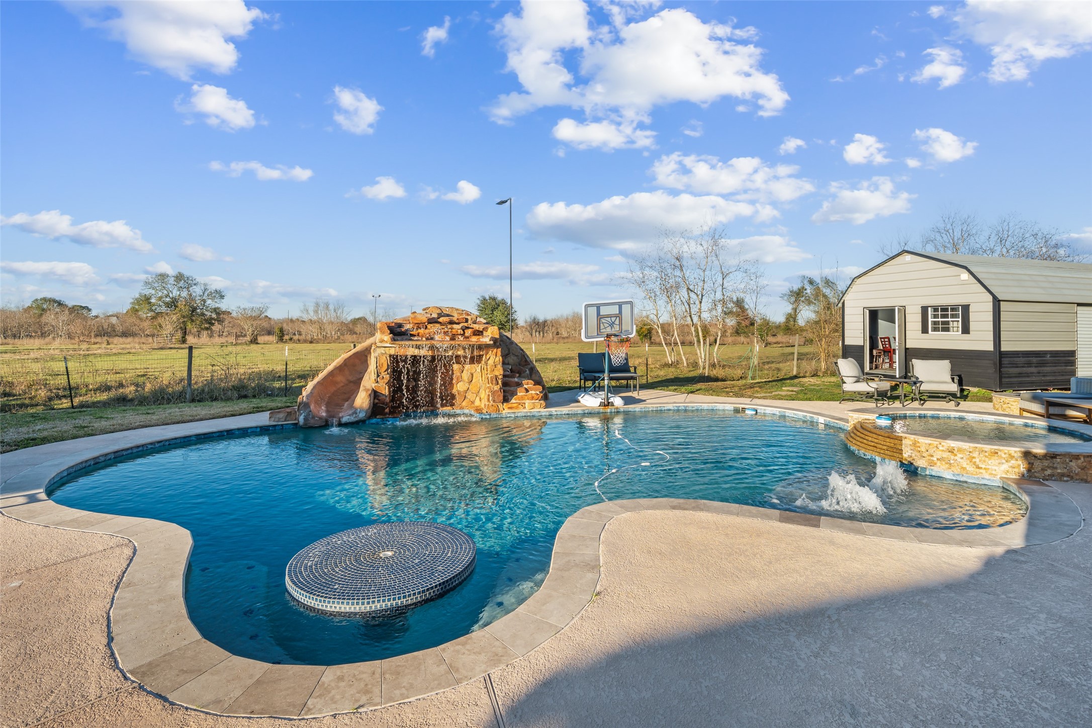43910 Highway 290 Business Prairie View, TX 77484 - Photo 37 of 49 Freeform pool with rock waterfall feature, tanning ledge, and integrated spa.