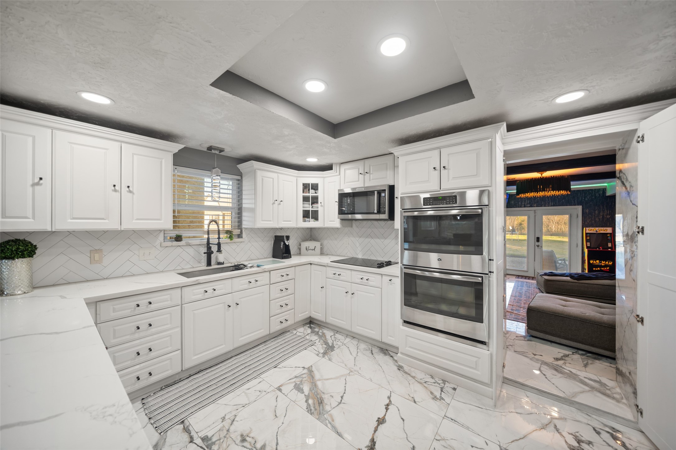 43910 Highway 290 Business Prairie View, TX 77484 - Photo 6 of 49 Bright kitchen with white cabinetry, quartz countertops, herringbone backsplash, and recessed lighting.
