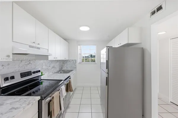 a kitchen with a stove a refrigerator and cabinets