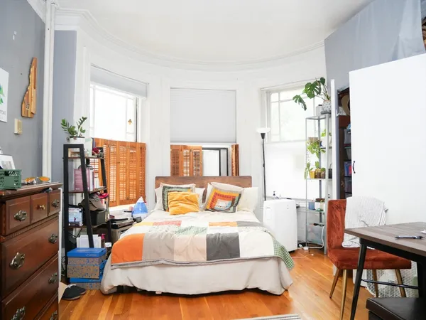 a bedroom with a bed and wooden floor