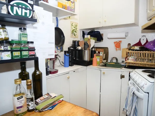 a view of a kitchen with fridge and workspace