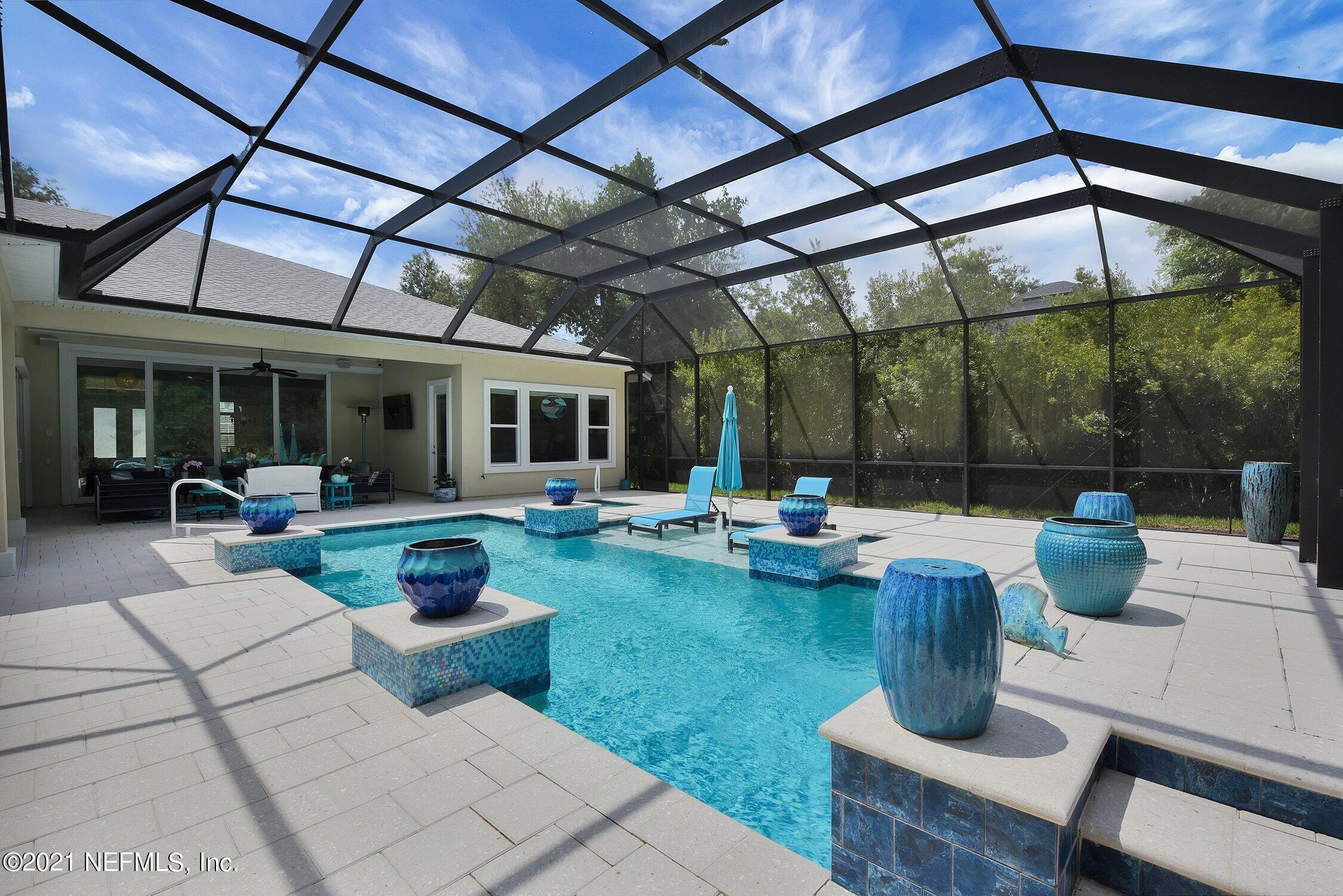 496 Costa Del Sol Drive St. Augustine, FL 32095 - Photo 90 of 111 a view of a patio with table and chairs potted plants and palm tree