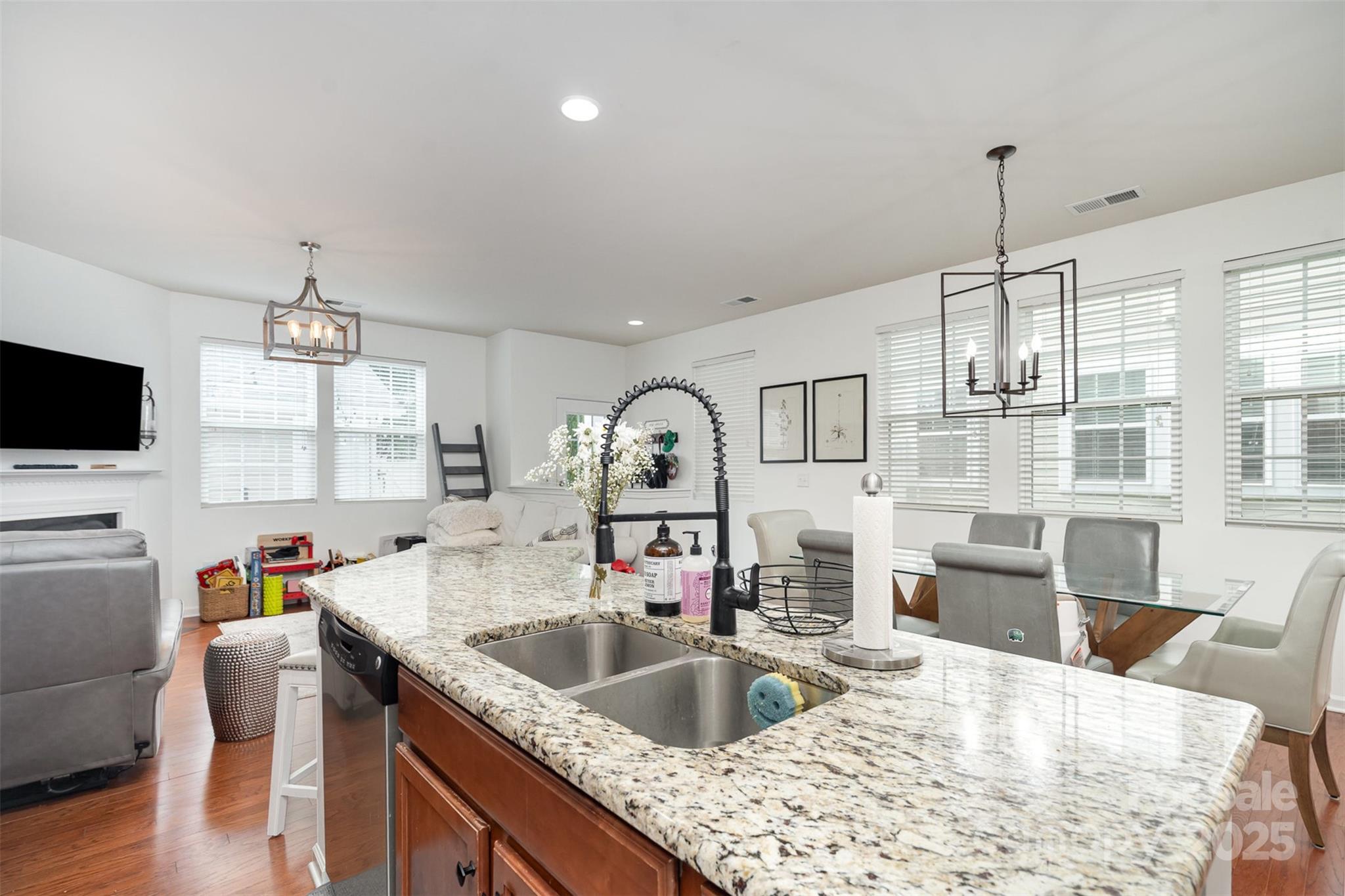 8245 Viewpoint Lane Cornelius, NC 28031 - Photo 11 of 32 a kitchen with stainless steel appliances granite countertop a sink dishwasher a microwave oven and a dining table with wooden floor