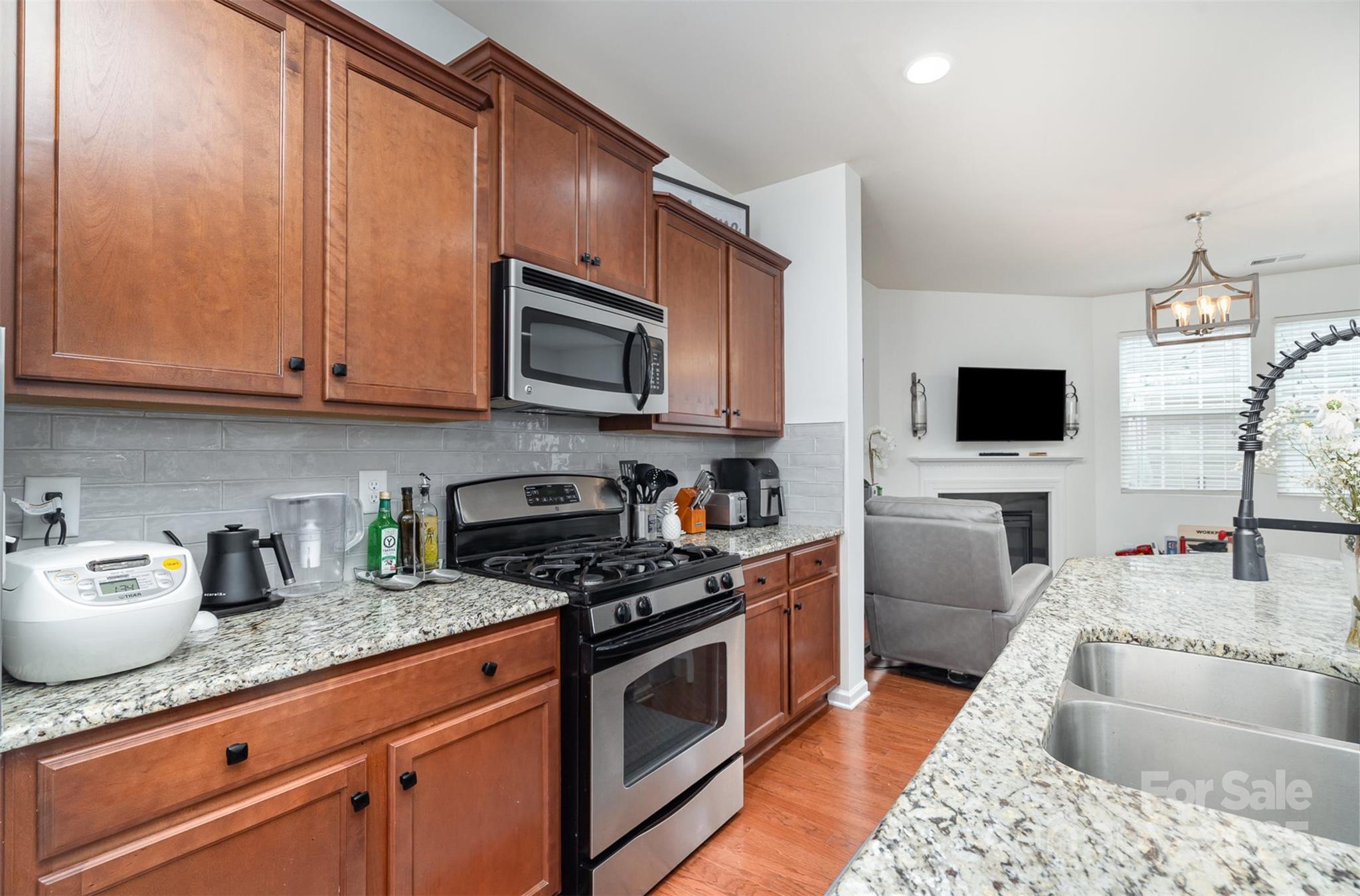 8245 Viewpoint Lane Cornelius, NC 28031 - Photo 10 of 32 a kitchen with granite countertop a sink a stove top oven a counter space and cabinets