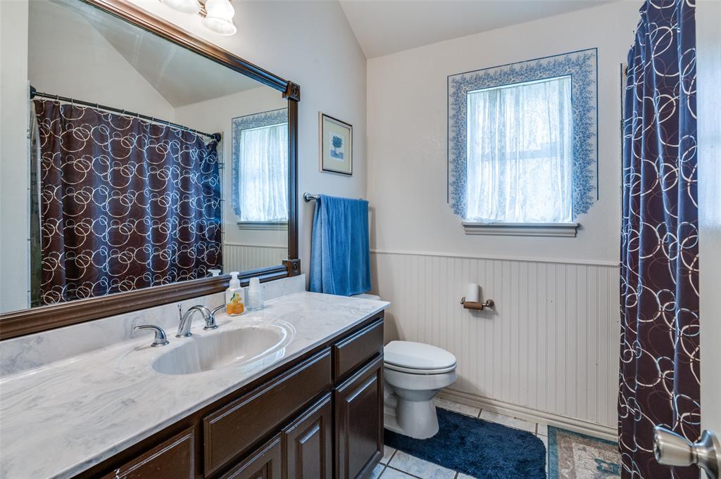 13420 Haslet Court Haslet, TX 76052 - Photo 17 of 26 a bathroom with a granite countertop sink toilet and shower