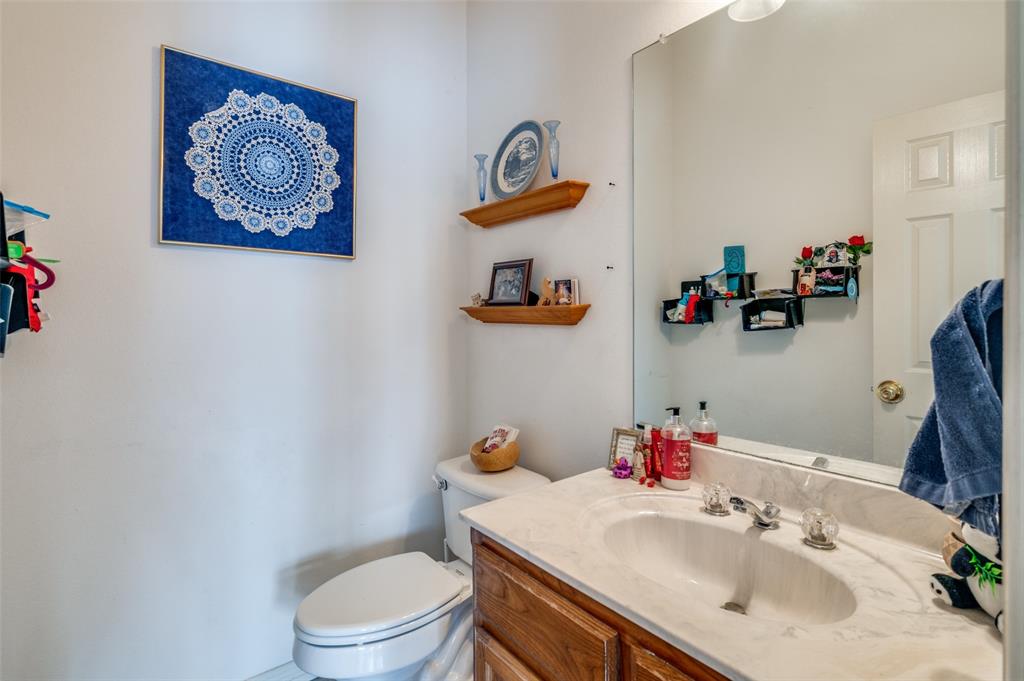 13420 Haslet Court Haslet, TX 76052 - Photo 22 of 26 a bathroom with a sink a toilet and a mirror