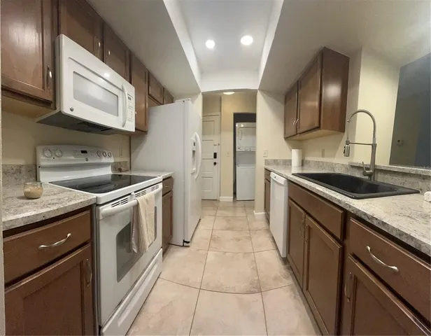a kitchen with a sink and a stove with wooden cabinets