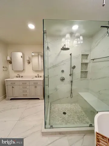 a bathroom with a double vanity sink mirror and shower