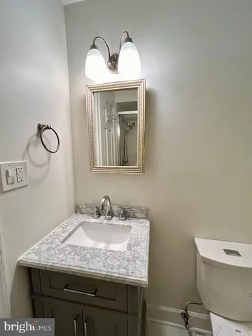 a en suite bathroom with a granite countertop sink and a mirror
