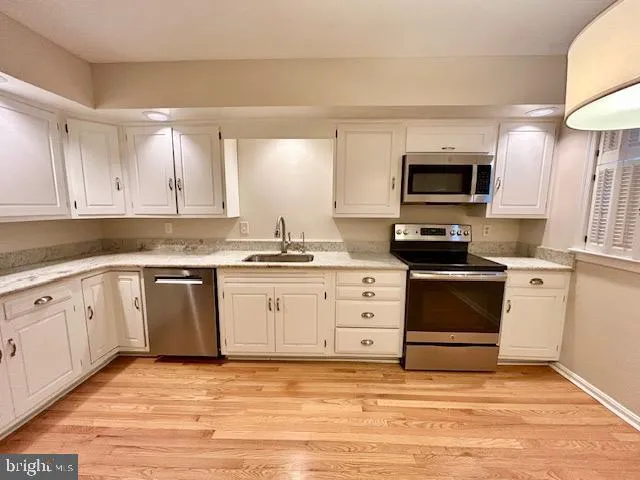 a kitchen with granite countertop a stove top oven microwave and cabinets