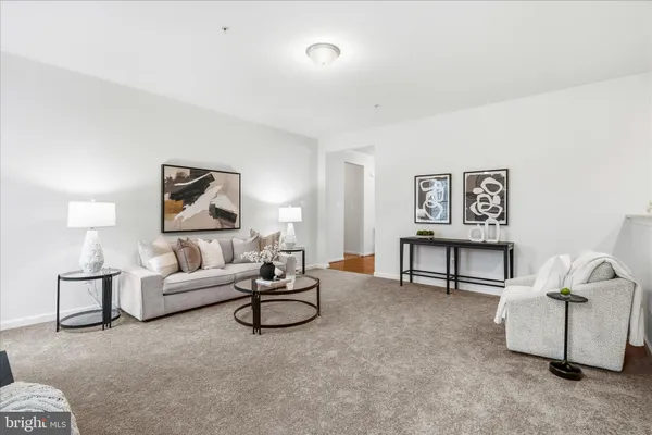 a living room with furniture and a painting on the wall