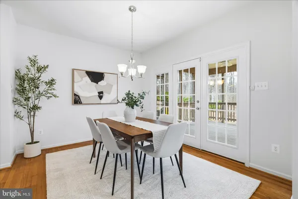 a dining room with furniture potted plants and wooden floor