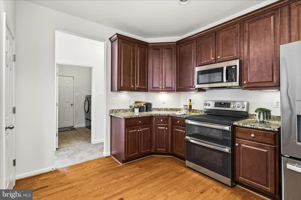 a kitchen with stainless steel appliances granite countertop wooden cabinets a stove top oven a sink and dishwasher