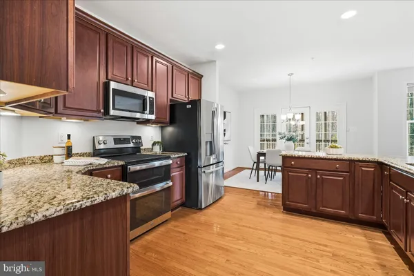 a kitchen with stainless steel appliances granite countertop wooden cabinets a stove top oven a sink and dishwasher