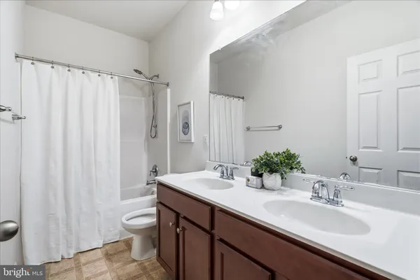 a bathroom with a double vanity sink toilet and a mirror