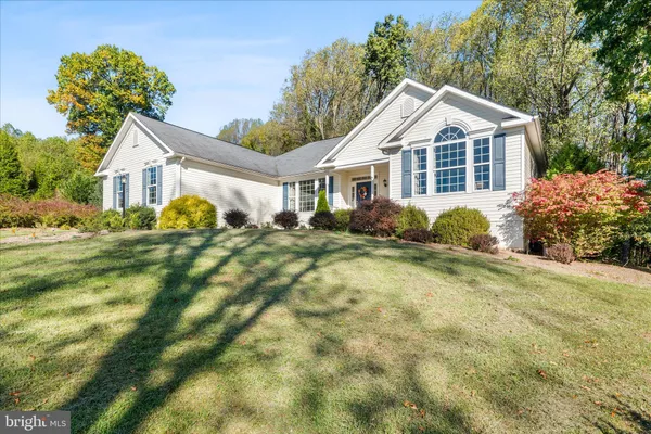 a front view of a house with a yard and trees