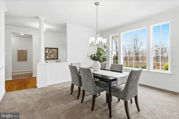 a dining room with furniture a chandelier and a rug