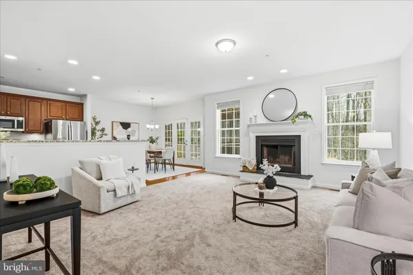 a living room with furniture a fireplace and a large window