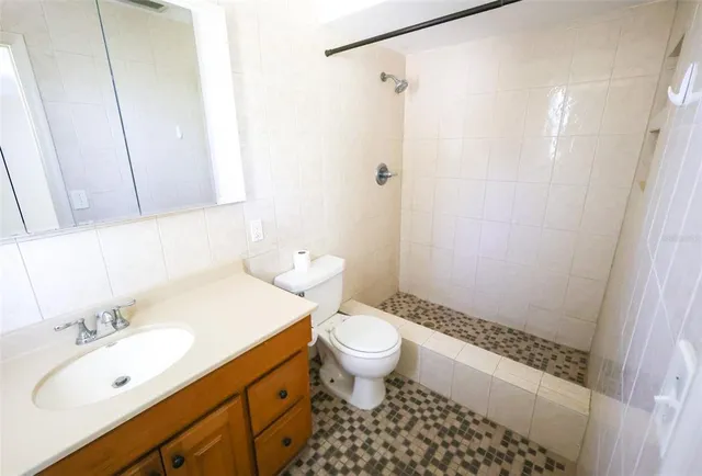 a bathroom with a sink a toilet a shower and a mirror