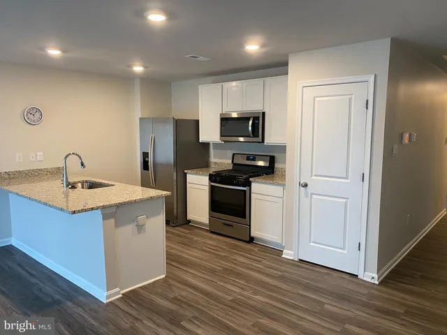 a kitchen with stainless steel appliances a refrigerator stove and sink