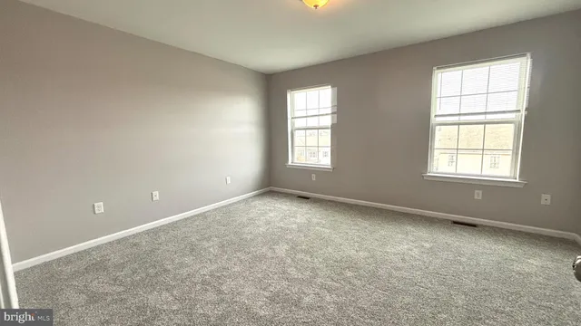 an empty room with windows & cabinet