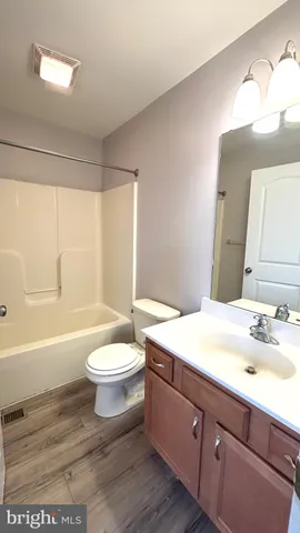 a bathroom with a sink a toilet a mirror and bathtub