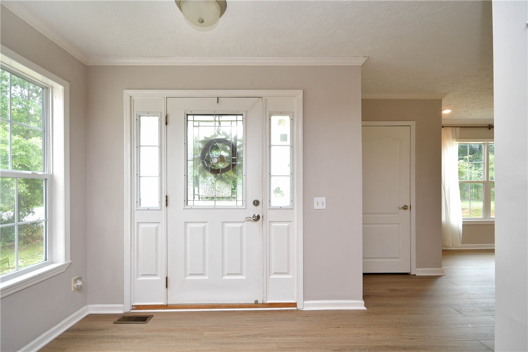 579 Daventon Road Honea Path, SC 29654 - Photo 5 of 44 A welcoming entry, with a decorative glass door, opens into a bright interior space featuring wide plank flooring.
