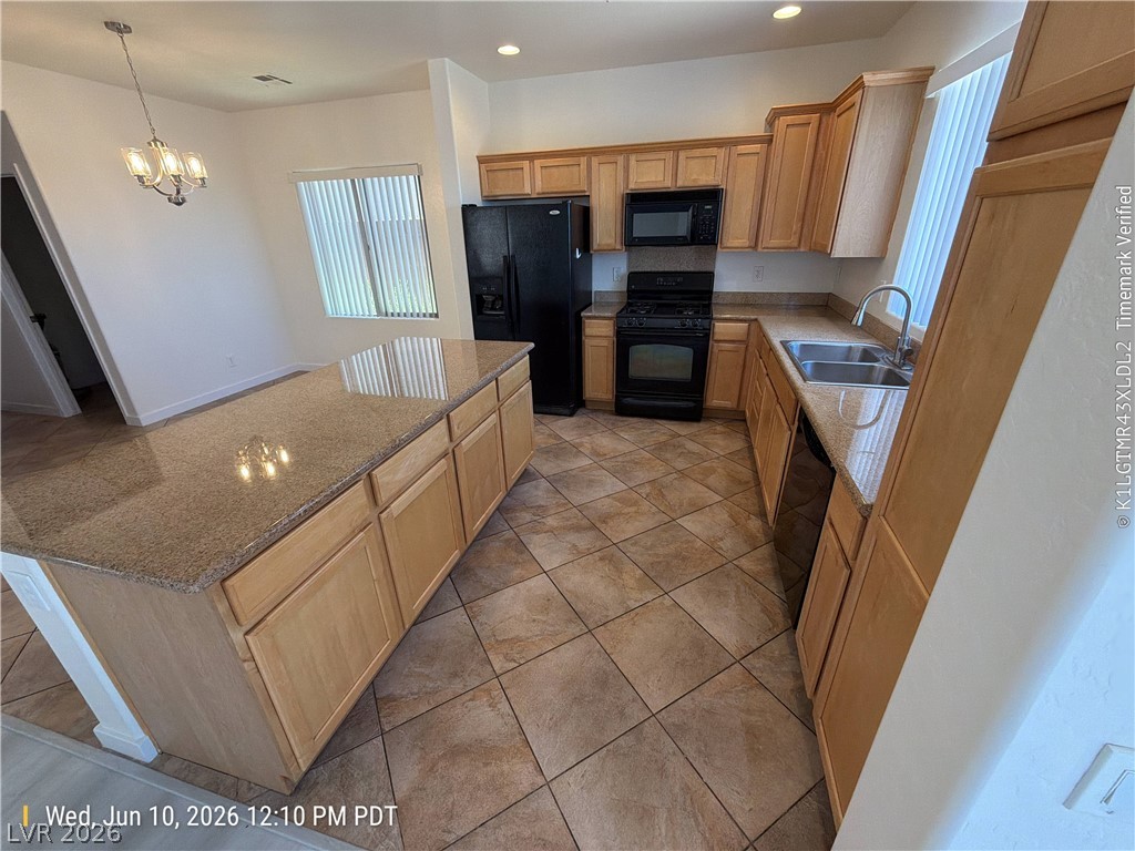 2388 Rue Bienville Way Henderson, NV 89044 - Photo 4 of 16 A well-appointed kitchen features warm-toned cabinetry, granite countertops, and tile flooring throughout.