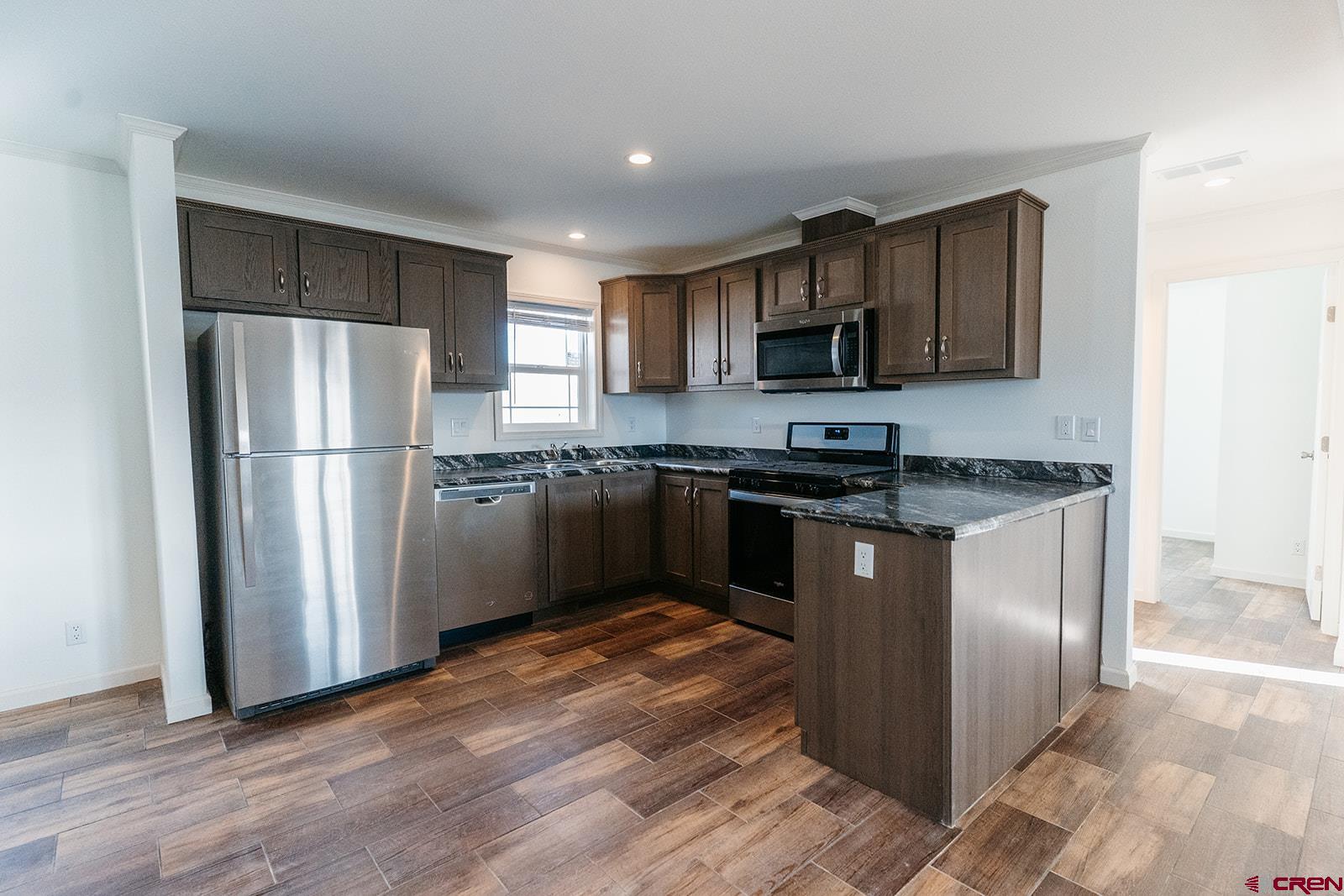 62650 Lasalle Road, Unit 820 Montrose, CO 81403 - Photo 14 of 29 a kitchen with granite countertop stainless steel appliances and wooden cabinets