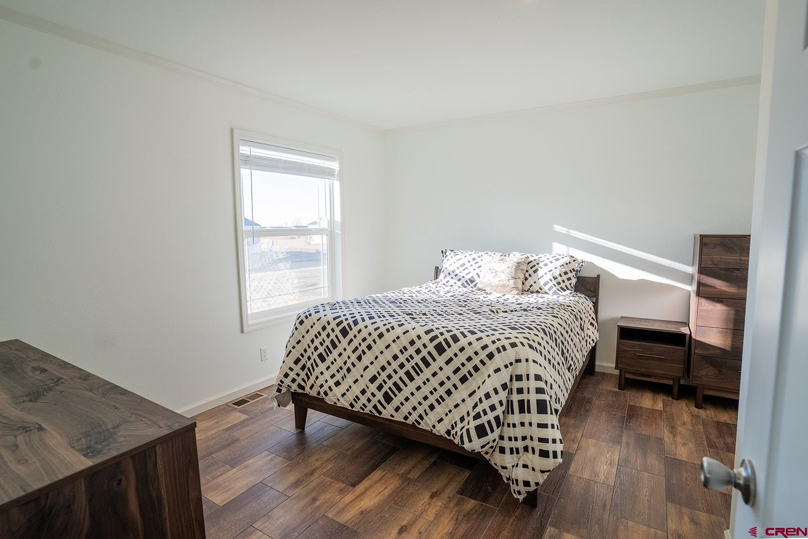 62650 Lasalle Road, Unit 820 Montrose, CO 81403 - Photo 19 of 29 a bedroom with a bed and wooden floor