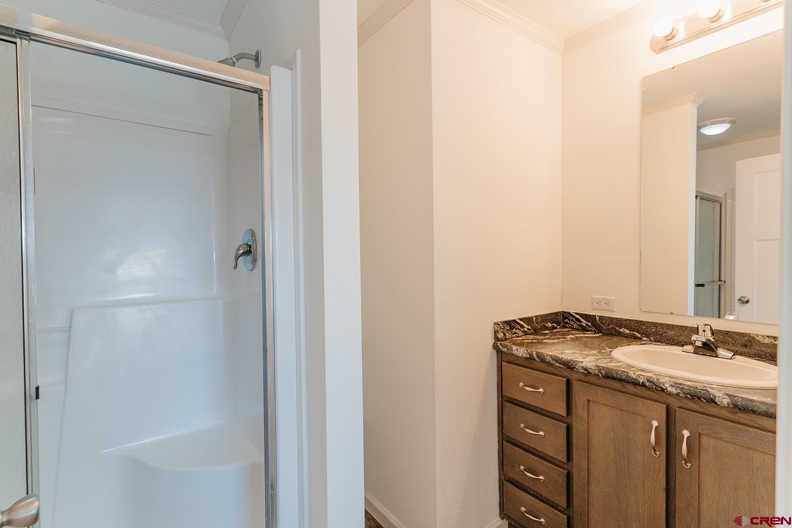 62650 Lasalle Road, Unit 820 Montrose, CO 81403 - Photo 20 of 29 a bathroom with a granite countertop sink and a mirror