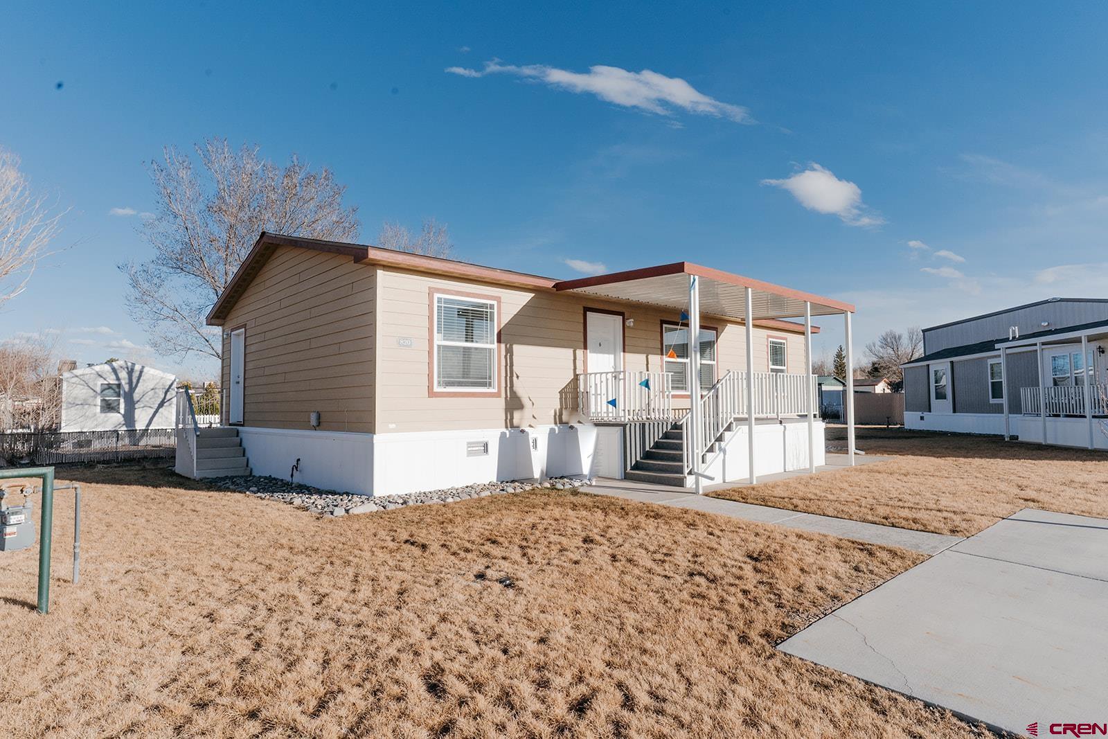 62650 Lasalle Road, Unit 820 Montrose, CO 81403 - Photo 2 of 29 a front view of a house with a yard and seating space