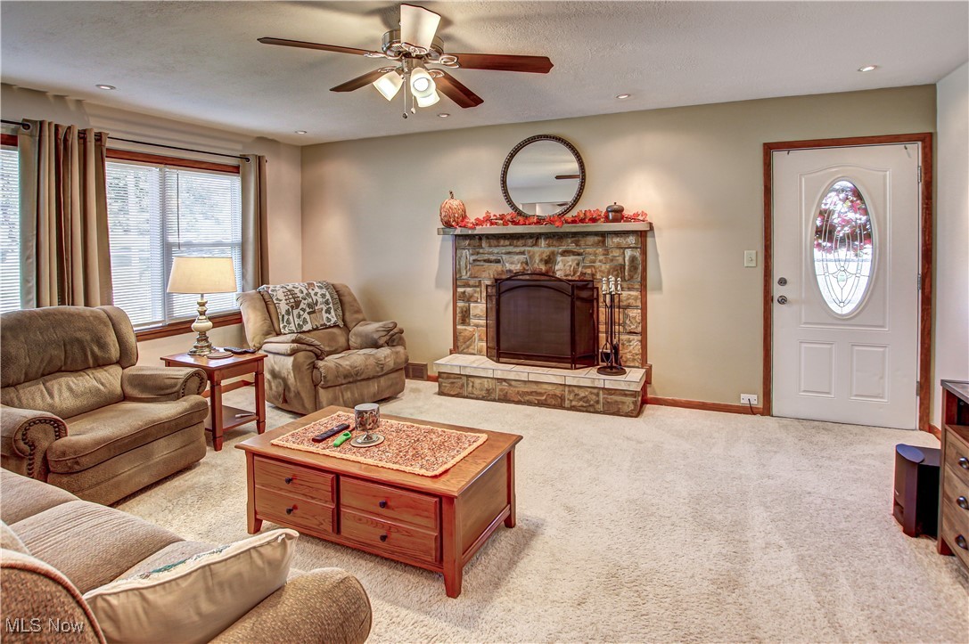 4234 Grafton Road Brunswick, OH 44212 - Photo 9 of 40 Carpeted living room featuring a textured ceiling, a fireplace, and ceiling fan