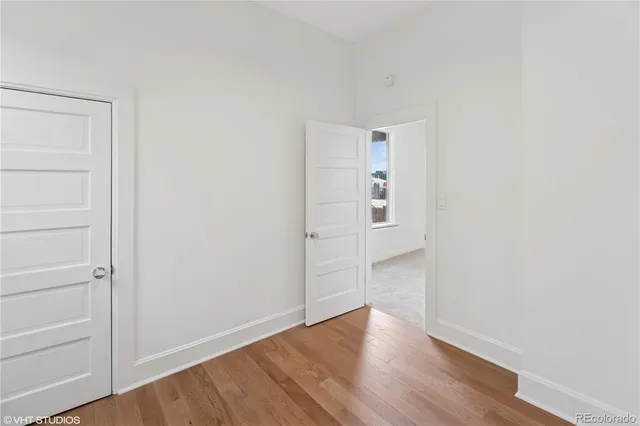 a view of an empty room with wooden floor
