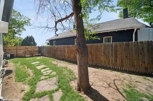 a view of backyard with wooden fence