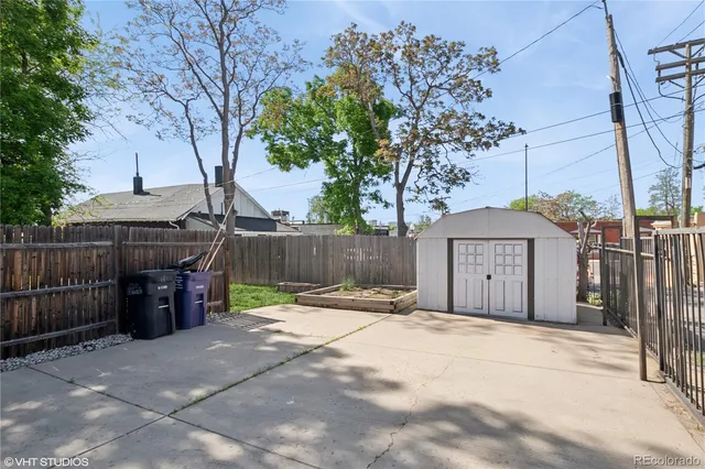 a view of a backyard with wooden fence and a large tree