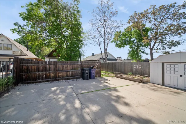 a view of a yard with a tree and wooden fence