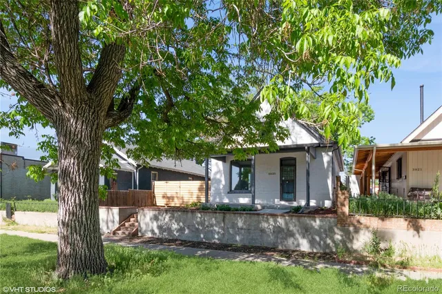a view of house with backyard and a tree