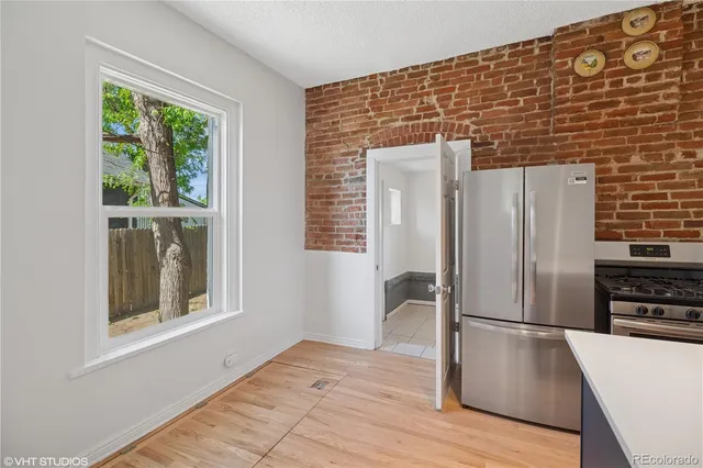 a view of a kitchen with wooden floor and electronic appliances
