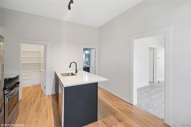 a kitchen with a sink a stove and cabinets