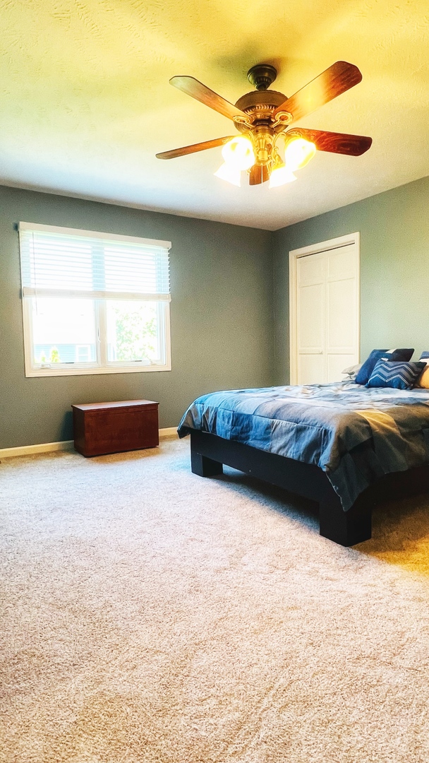 4 Downing Circle Bloomington, IL 61704 - Photo 39 of 69 a bedroom with a bed and a chandelier