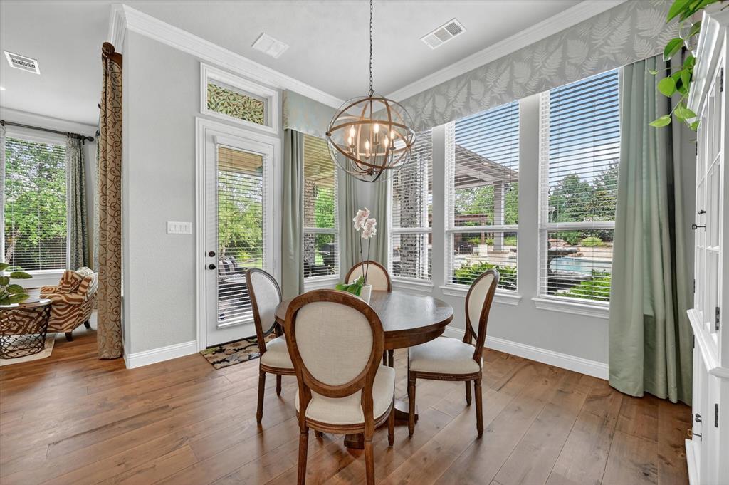 6656 Roughleaf Ridge Road Flower Mound, TX 76226 - Photo 14 of 40 a dining room with wooden floor a chandelier a glass table and chairs