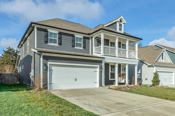 a kitchen with stainless steel appliances kitchen island granite countertop a dining table chairs sink and white cabinets