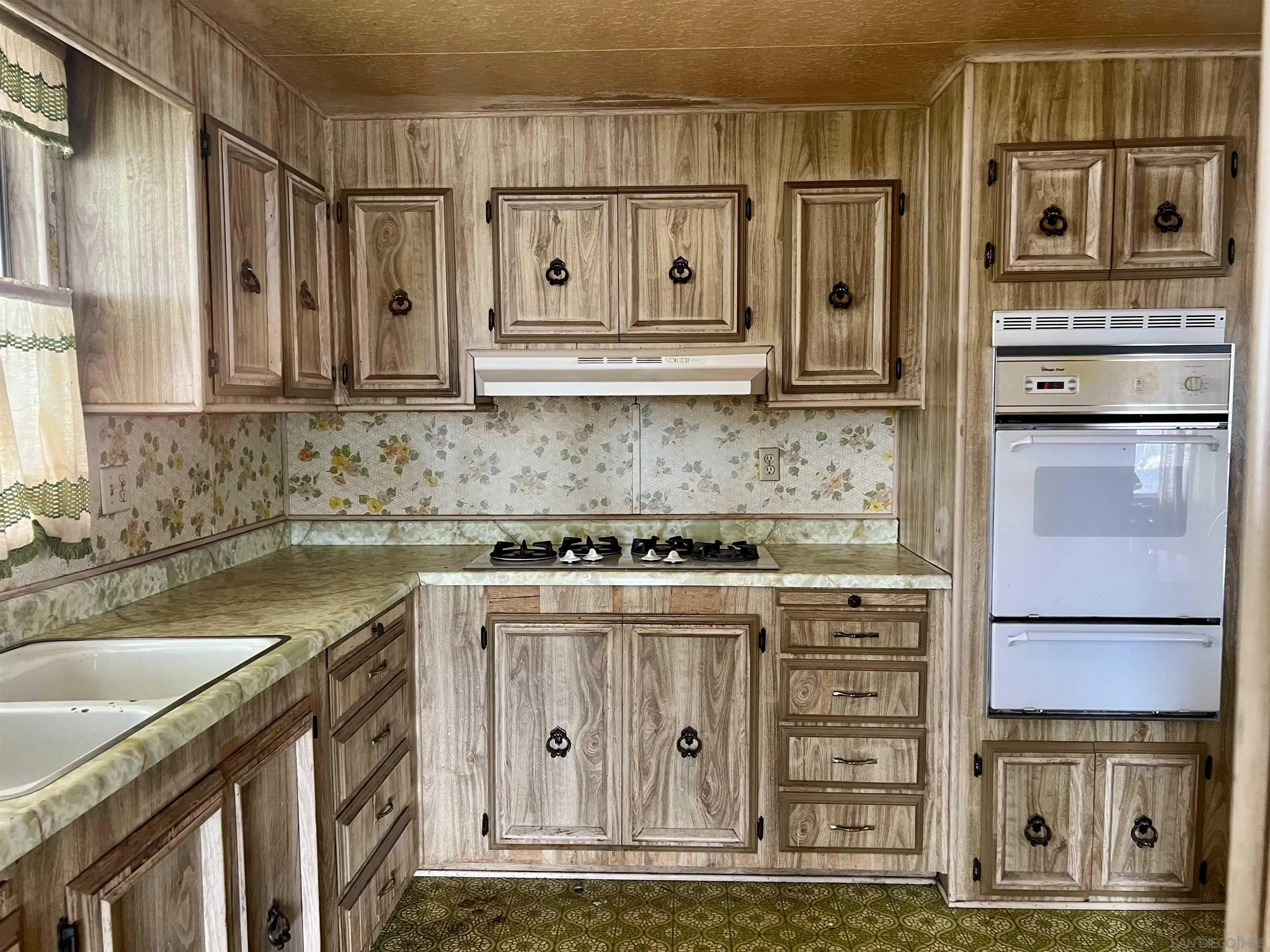 809 Olive Avenue, Unit 11 Vista, CA 92083 - Photo 11 of 26 a kitchen with stainless steel appliances granite countertop a refrigerator a stove and a sink with wooden cabinets