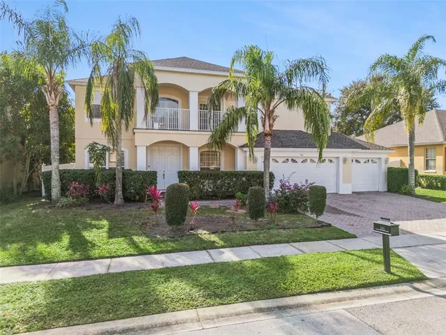 a front view of a house with a yard and potted plants
