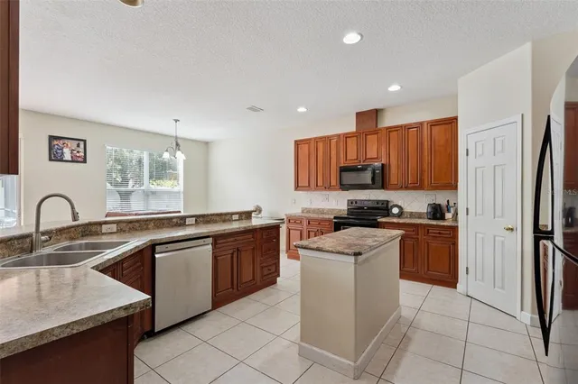 a kitchen with stainless steel appliances granite countertop a sink dishwasher stove top oven and refrigerator