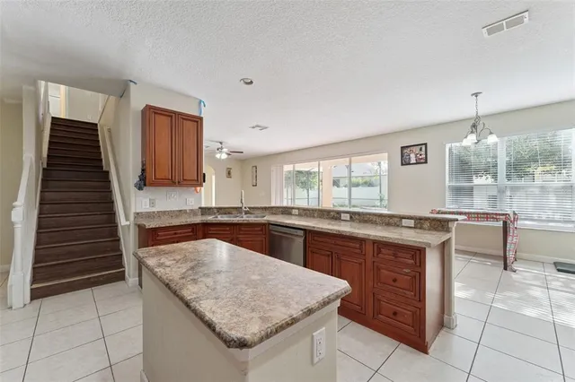 a kitchen with granite countertop a stove a sink and a microwave