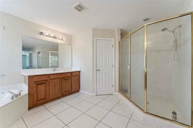 a spacious bathroom with a mirror a shower and a sink