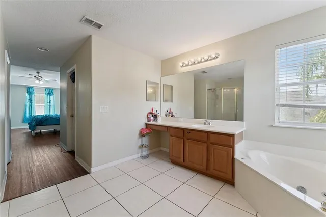a spacious bathroom with a tub sink and mirror